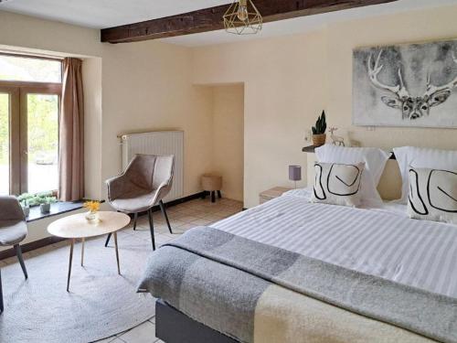 une chambre avec un grand lit et une table et des chaises dans l'établissement Au Coeur d'Alle by Belvilla, à Alle