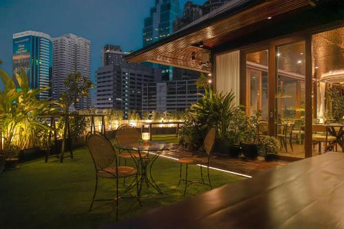 a patio with chairs and a table with a view of the city at Metro Pratunam Boutique Hotel in Pratunam