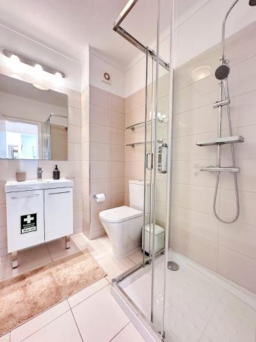 a bathroom with a shower and a toilet and a sink at WindMill Rooftop Panoramic OceanView Condo By BeCherish in Albufeira