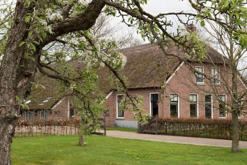 a brick house with a fence in front of it at Silo 161 in Ruinerwold