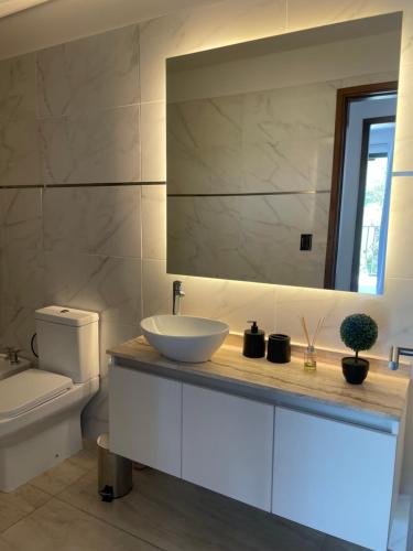 een badkamer met een wastafel en een spiegel bij Balcón Andino in Maipú