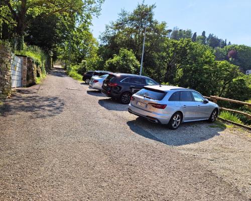 a row of parked cars parked on a gravel road at Foresteria Antica Bastia B&B in Bergamo