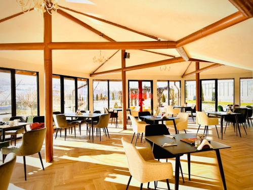 een restaurant met tafels, stoelen en ramen bij Park Hotel Eagle Stone in Koprivshtitsa