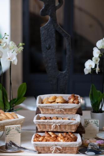 drie mandjes met gebak staan op een tafel. bij Les Jardins du Faubourg Hotel & Spa by Shiseido in Parijs