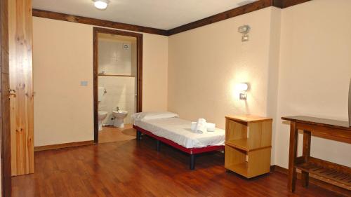 een slaapkamer met een bed en een badkamer met een toilet bij Hostdomus - Betulle Apartments in Sestriere