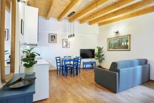 a living room with a table and a blue couch at Residence "Professor's nest" - Verona Apartments in Verona