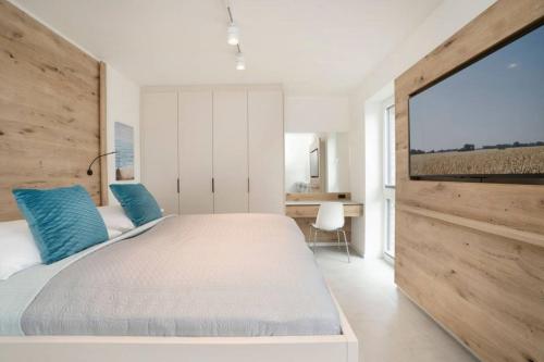 a bedroom with a large bed with blue pillows at Dahmer Strand 5 in Dahme