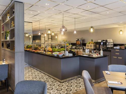 a restaurant with a counter filled with food at Mercure Hotel Amsterdam West in Amsterdam