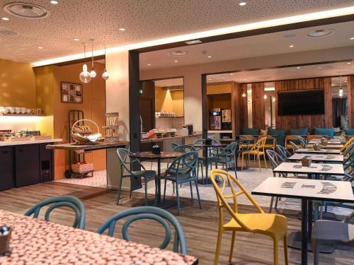 a restaurant with tables and chairs and a cafeteria at ibis Dijon Gare in Dijon