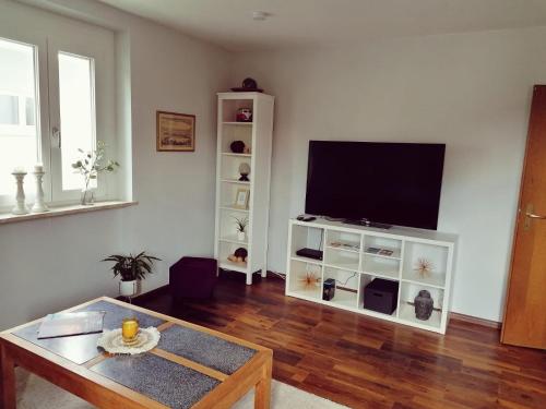 een woonkamer met een flatscreen-tv aan de muur bij Ferienwohnung Südschwarzwald in Wehr