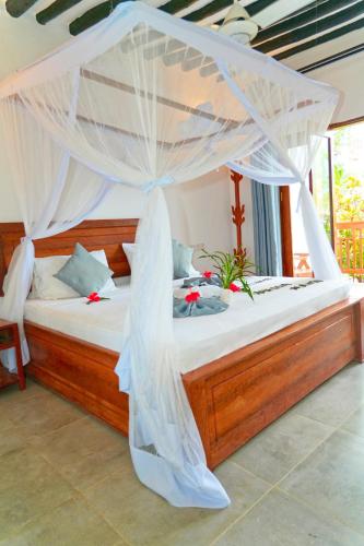 a bedroom with a bed with a mosquito net at Bustan in Matemwe
