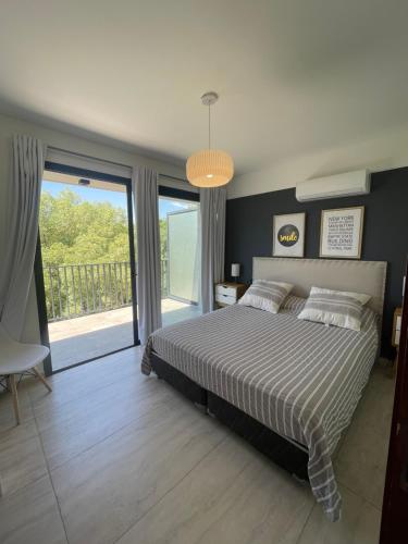 een slaapkamer met een bed en een groot raam bij Balcón Andino in Maipú