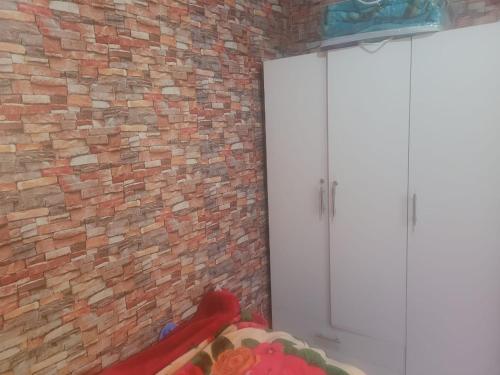 a room with a brick wall and a white door at بيت مع وجبة إفطار لمشجعي كأس الأمم الأفريقية in Fez