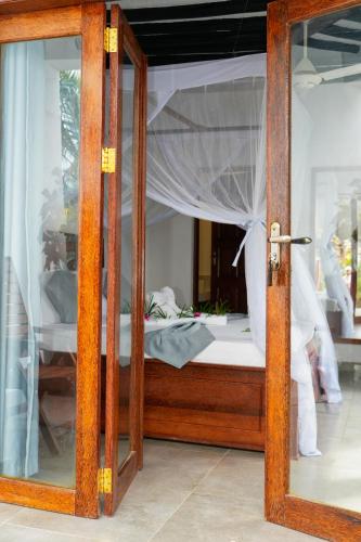 an open door to a bedroom with a bed at Bustan in Matemwe