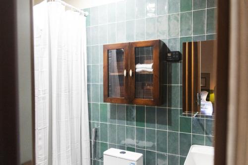 a bathroom with a green tiled wall with a toilet at بيت أبي علي in Abha