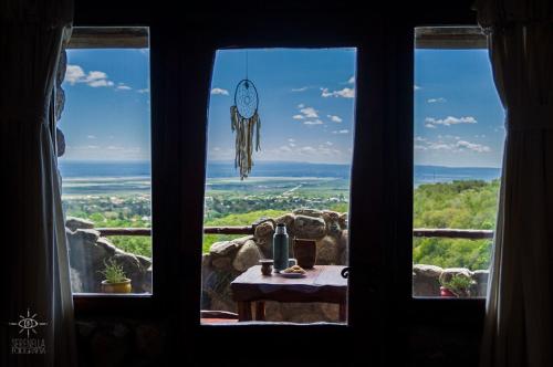 een raam met uitzicht op een tafel en een klok bij Hostería Vegetariana in Country Club Chumamaya
