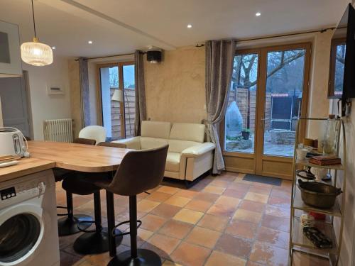 eine Küche und ein Wohnzimmer mit einem Tisch und einer Couch in der Unterkunft Studio 2 personnes proche du Futuroscope in Beaumont