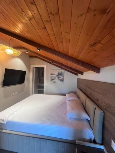 a bedroom with a large bed with a wooden ceiling at Bella Vista Rezidence in Pogradec