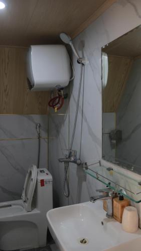 ein Badezimmer mit Toilette, Waschbecken und Spiegel in der Unterkunft Pavi Lodge in Mèo Vạc