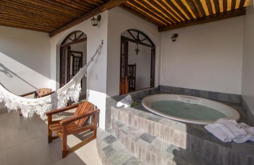 une salle de bains avec une baignoire jacuzzi et une chaise dans l'établissement Pousada Natureza, à Morro de São Paulo