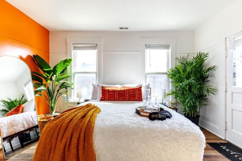 een slaapkamer met een groot bed met oranje muren bij Jungle House Columbus Downtown Free Parking Sleeps 8 - Near Convention Center & Nationwide Arena - 2BR Luxury Home - Pet Friendly Over 5,800 Five Star Stays in Columbus
