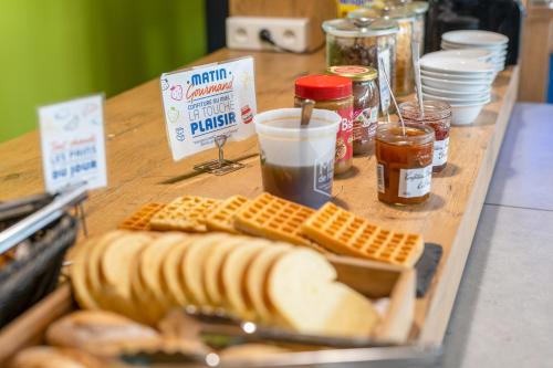 een tafel vol hotdogs, brood en sauzen bij Ibis budget Brest Sud Plougastel - Hôtel rénové in Plougastel-Daoulas