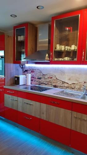 a kitchen with red cabinets and a counter top at Ferienwohnung ILSENHOF in Königsbrück