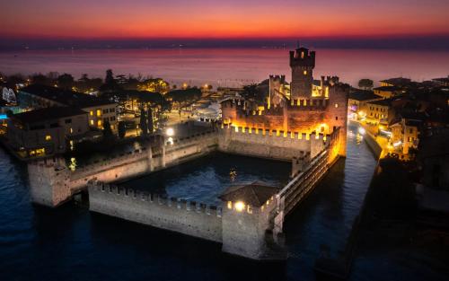 een brug over een rivier met een stad in de nacht bij Hotel Alfieri in Sirmione