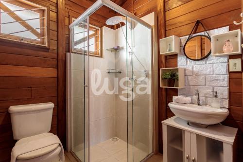 ein Badezimmer mit Dusche, Toilette und Waschbecken in der Unterkunft Casa Aconchegante – A 200m da praia da Pinheira in Pinheira