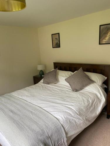 a bedroom with a white bed with two pillows at Private modern guest house in Yetminster