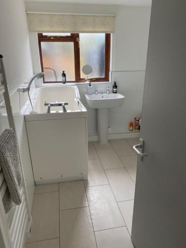 a white bathroom with a sink and a mirror at Private modern guest house in Yetminster