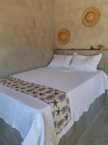 een slaapkamer met 2 bedden met witte dekens en kussens bij Yahweh Guriú in Camocim