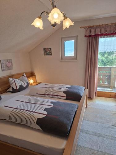 a bedroom with two beds and a window at Berghaus Edelstein in Bodenmais in Bodenmais