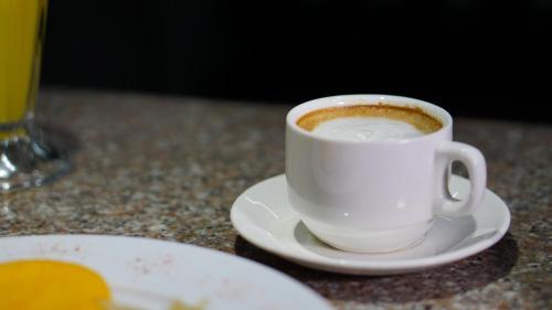 une tasse de café sur un plateau sur une table dans l'établissement Hotel Benidorm Panama, à Panama City