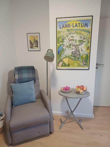 a living room with a chair and a table with a map at Gästewohnung Illa in Meerbusch