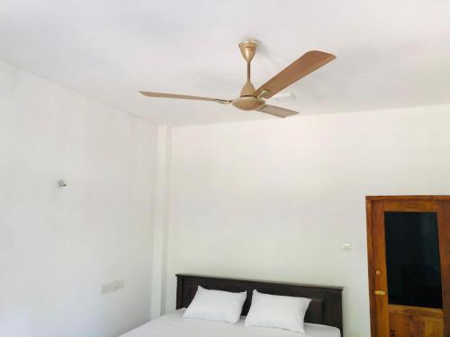 a ceiling fan sitting on top of a bed at Nimal's villa in Midigama East
