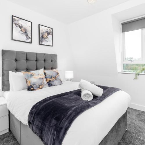 a bedroom with a large bed with a black and white blanket at Modern Two Bed Apartment - Netflix - Balcony - Parking - 5MC in Birmingham