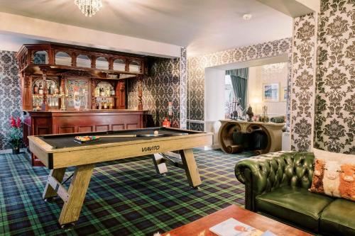 a living room with a pool table and a couch at Muthu Queens Hotel, Oban in Oban