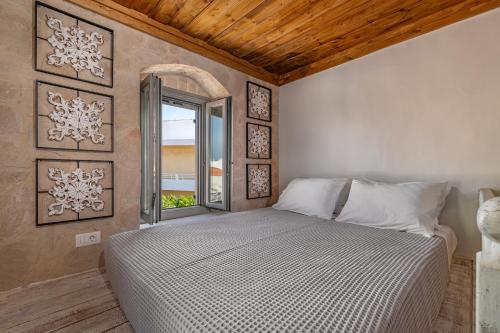 a bedroom with a large bed and a window at Melitia Traditional House in Koskinou