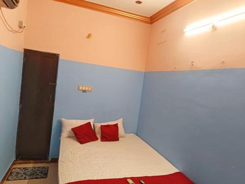 een slaapkamer met een bed met 2 rode kussens bij Le Casa Stay in Pondicherry