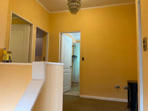 a bathroom with a yellow wall and a mirror at Casa piedra in Puerto Montt