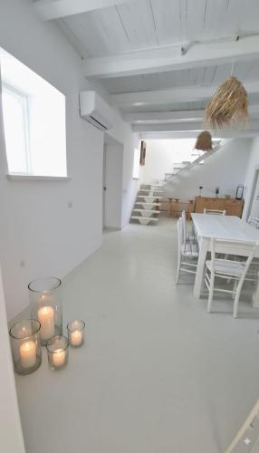 una stanza bianca con candele e un tavolo con sedie di Alma Capodimonte Lake chalet a Capodimonte