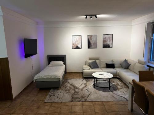 een woonkamer met een bank en een tafel bij 70qm Apartment mit Stellplatz und Garten in Riegelsberg