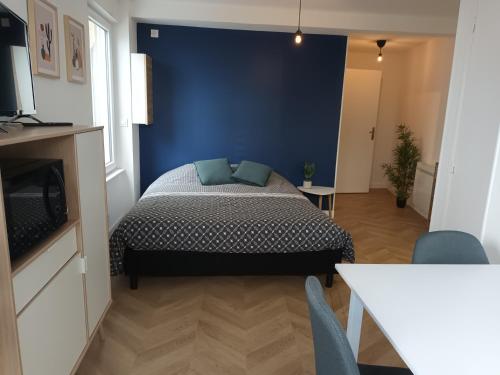 een slaapkamer met een bed en een blauwe muur bij studio trankil coeur d'Ancenis - balcons d'Ancenis in Ancenis