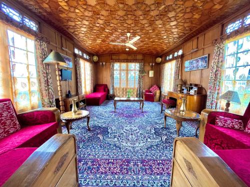 a living room with pink furniture and windows at Vanda Heritage Houseboats in Srinagar