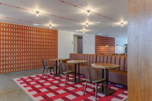 a restaurant with tables and chairs on a red and white rug at Upon Harbor - Seixal Bay Hotel in Seixal