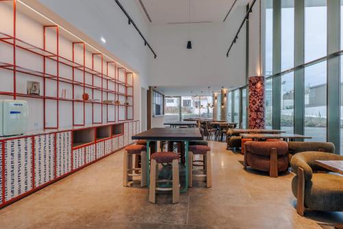 a restaurant with tables and chairs and windows at Upon Harbor - Seixal Bay Hotel in Seixal