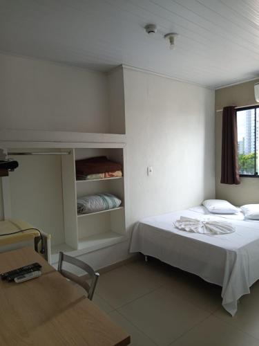 a small room with a bed and a window at Hotel BLESS in Cascavel