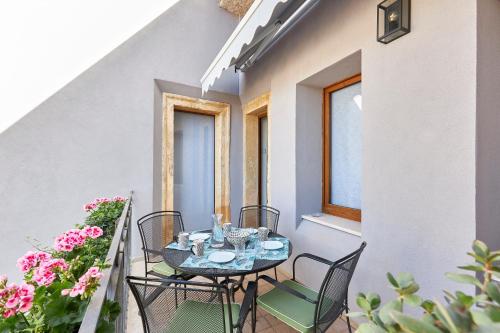 a table and chairs on a balcony with flowers at Residence "Professor's nest" - Verona Apartments in Verona