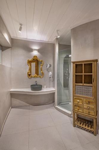a bathroom with a sink and a shower and a mirror at Melitia Traditional House in Koskinou